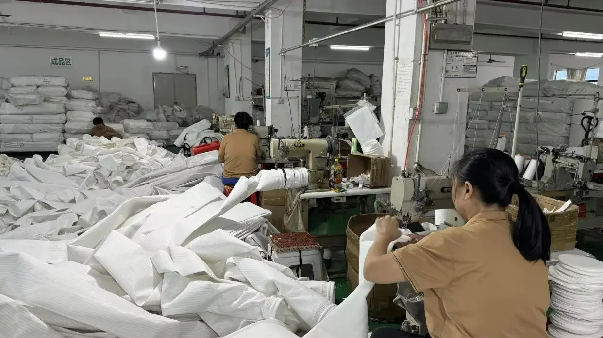 Guanlin workers sewing industrial filter bags